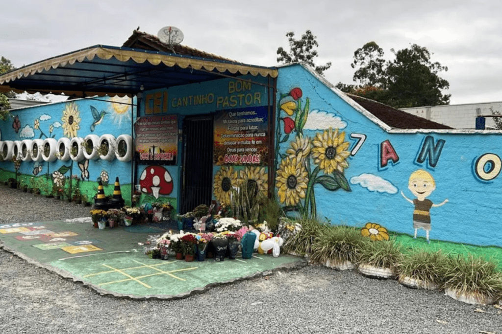 Frente da Creche Cantinho Bom Pastor, em Blumenau, com flores á frente.