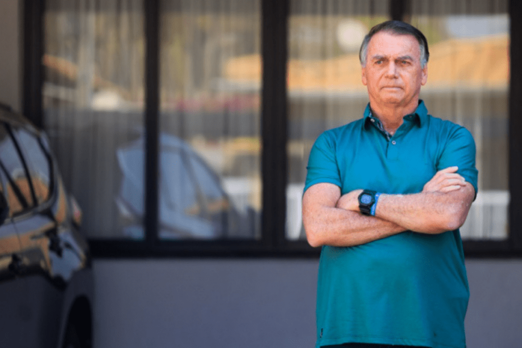 Ex-presidente Jair Bolsonaro de pé ao lado do carro