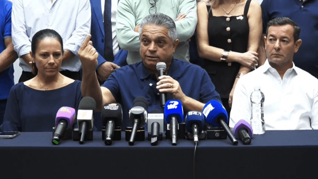 Imagem de João Rodrigues em coletiva de imprensa com vários microfones a frente