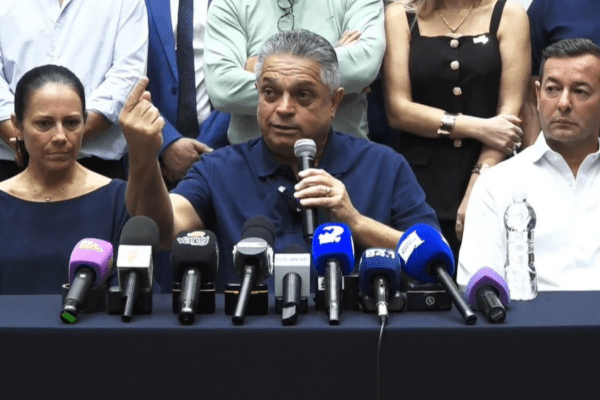 Imagem de João Rodrigues em coletiva de imprensa com vários microfones a frente