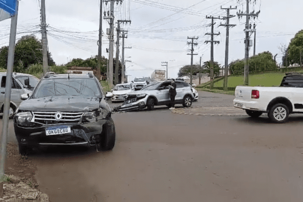Imagem de dois veículos com a frente amassada no cruzamento de ruas.