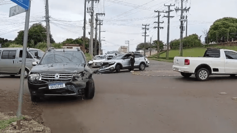Imagem de dois veículos com a frente amassada no cruzamento de ruas.