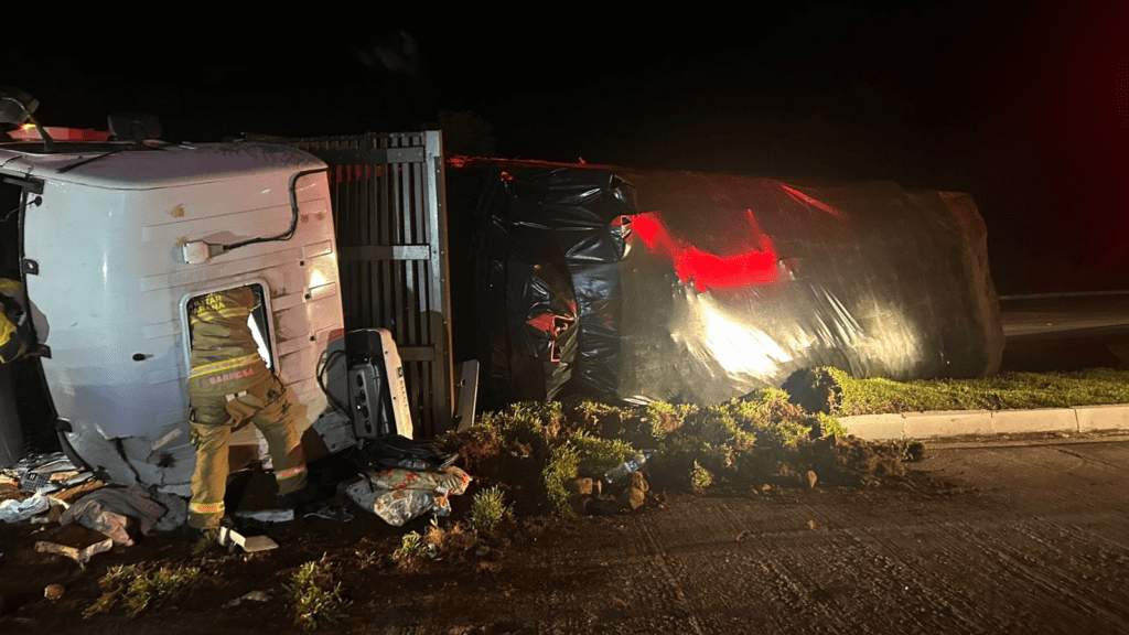 Imagem caminhão tombado á noite.