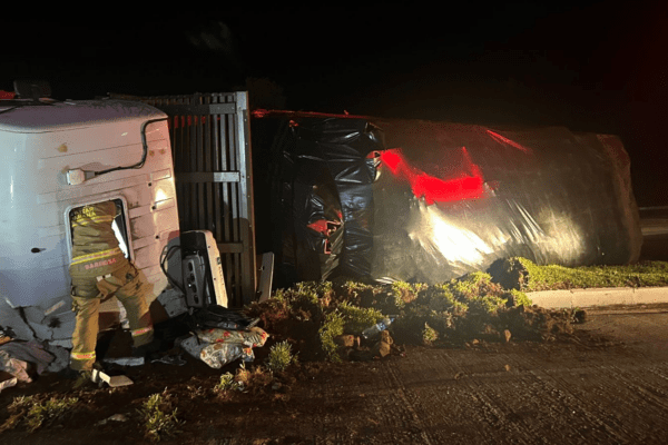 Imagem caminhão tombado á noite.