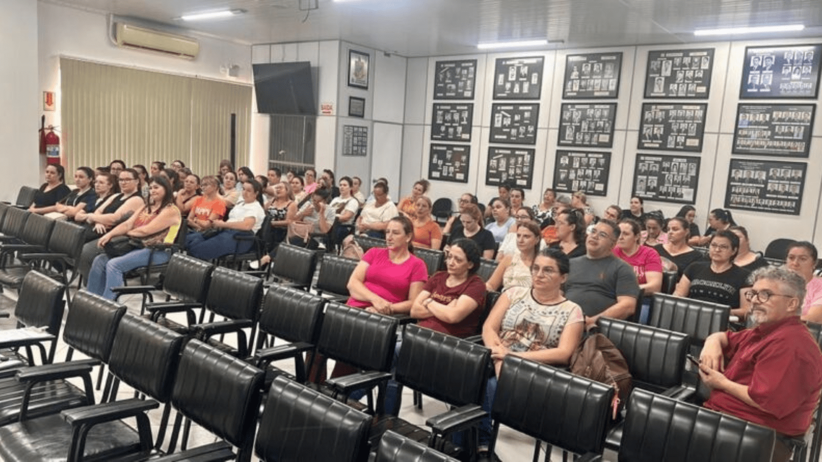 Auditório com várias pessoas sentadas.