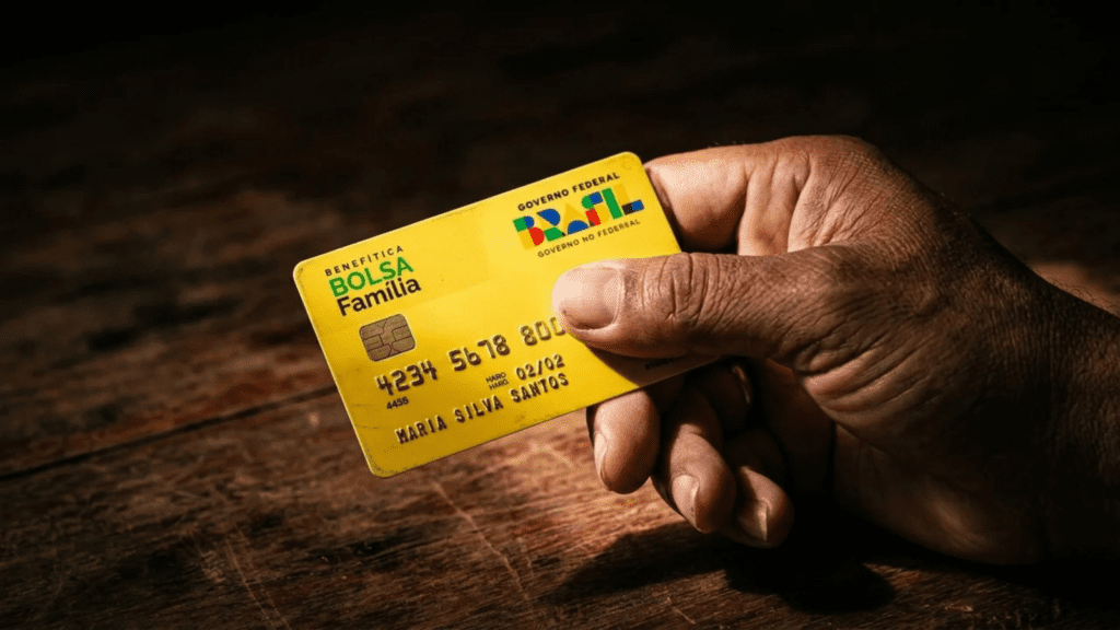 Mão segurando cartão do programa Bolsa Família