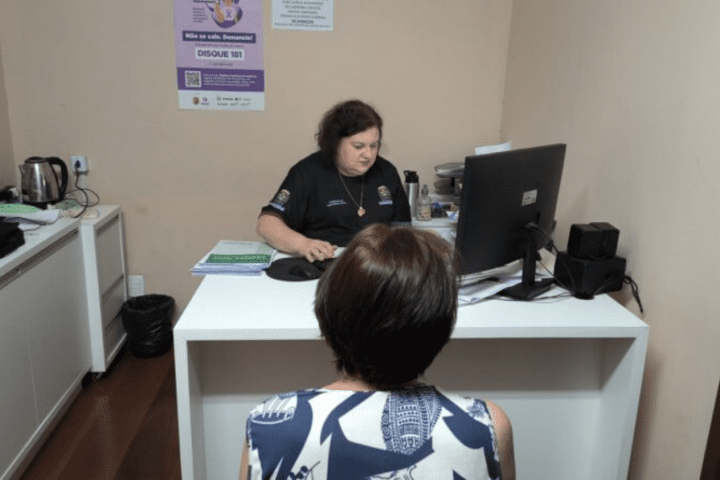 Agente da prefeitura em escritório atendendo cidadão que possui Bolsa Família