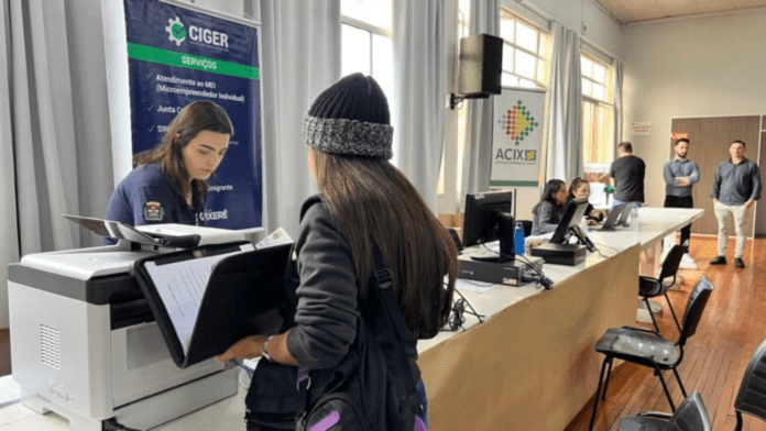 Pessoa em frente á um balcão no feirão do emprego de Xanxerê