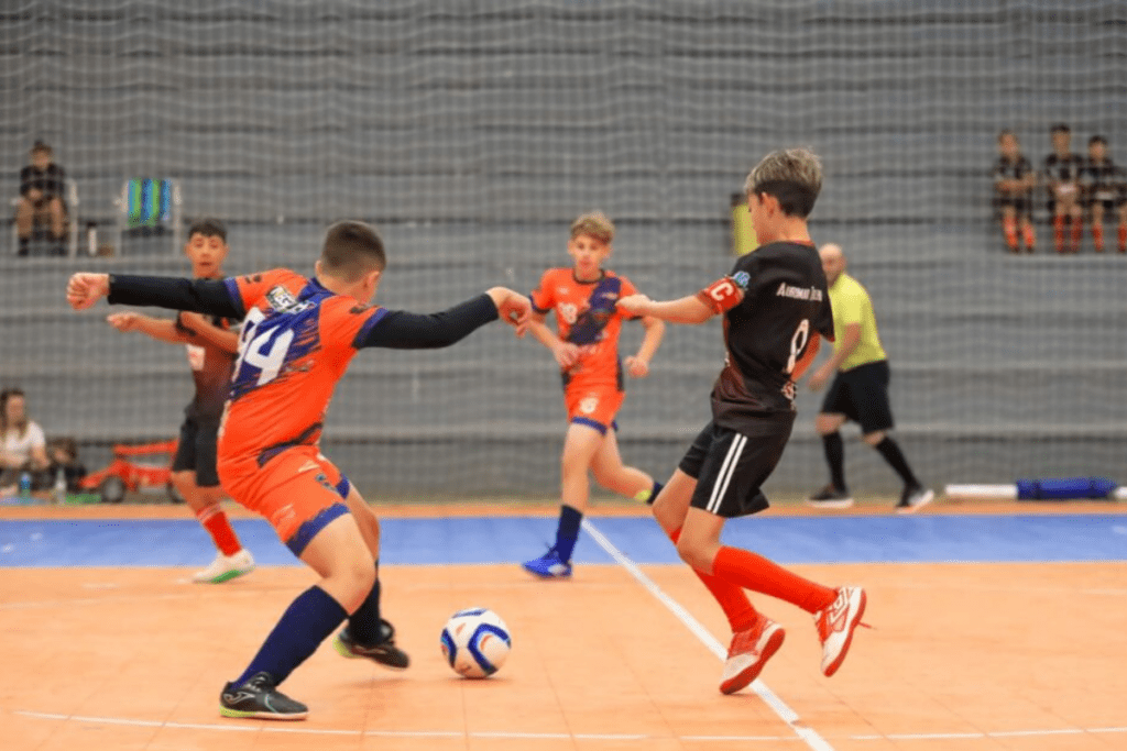 Jogadores em quadra disputando a bola na Copa Municipal de Futsal de Xanxerê