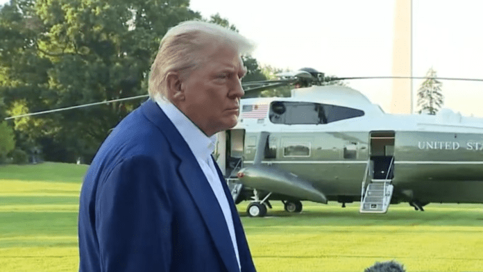Donald Trump com helicóptero presidencial ao fundo.