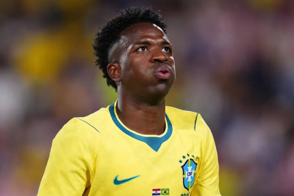 Jogador Vini Jr com a camisa da seleção, em campo.