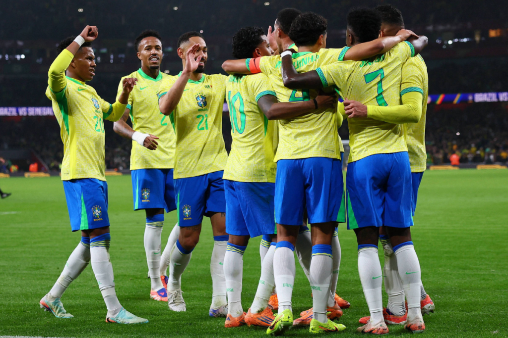 Jogadores da Seleção brasileira de futebol comemorando e se abraçando em campo.