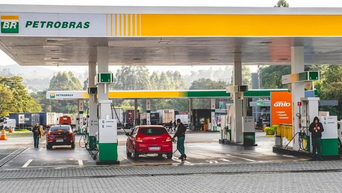 Posto de combustível da Petrobrás com um veículo vermelho sendo atendido por um frentista