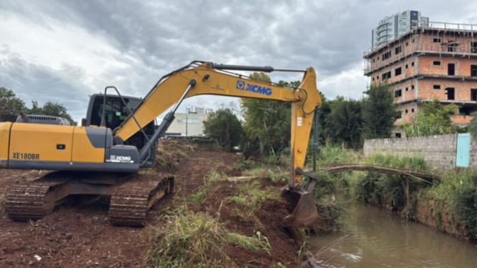 Máquina da prefeitura faz desassoreamento do rio Xanxerê.