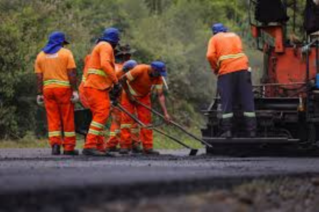 Trabalhadores durante pavimentação asfáltica de rodovia