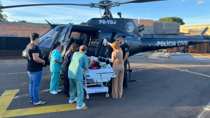 Equipe do SAMU carregando o helicóptero do Saer-Fron com maca que está bebê que sofreu queimaduras em Nova Erechim
