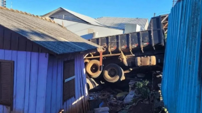 Casa de madeira com caminhão caçamba que entrou pela parede lateral