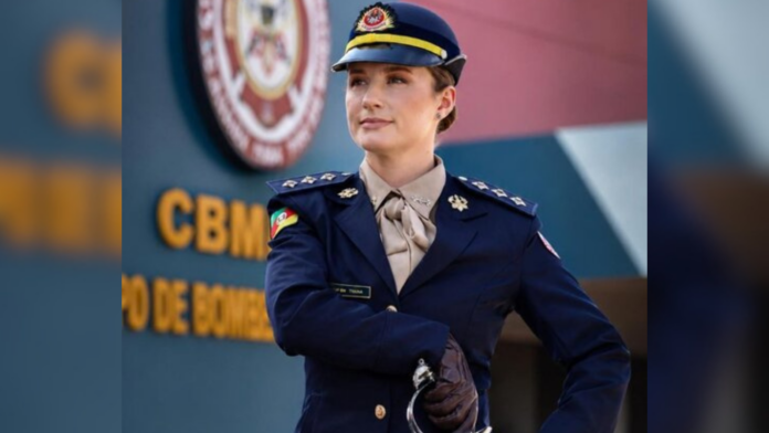 Capitã Thainá Marina Marques Scheleski fardada segurando cabo na espada que está na cintura