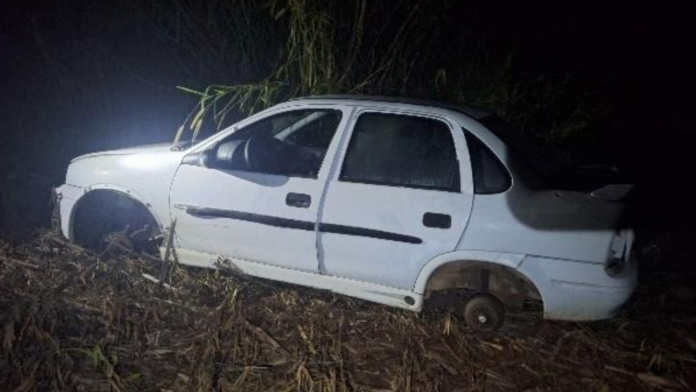 Veículo GM Corsa branco abandonado sem rodas e partes da lataria após ter sido furtado