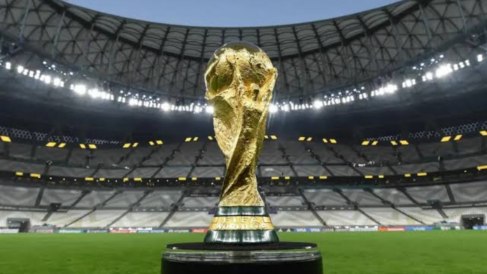 Troféu da Copa do Mundo da FIFA em uma mesa na frente do gramado de um estádio