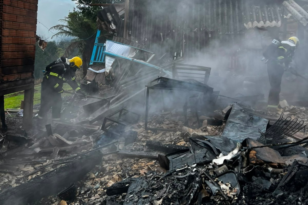 Bombeiro efetuando rescaldo em casa que foi destruída pelo fogo no interior Seara/SC
