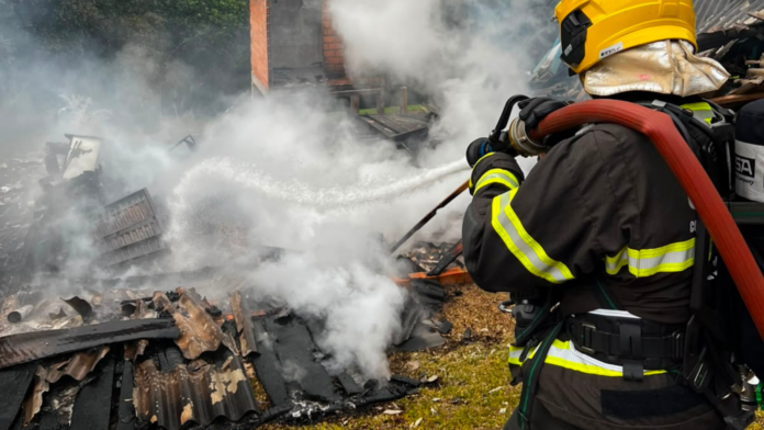 Bombeiro efetuando rescaldo em casa que foi destruída pelo fogo em Seara