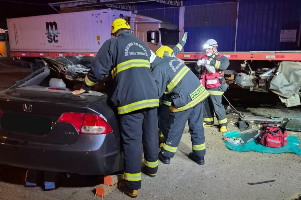Veículo com lateral aberta após acidente em Concórdia e bombeiros retirando passageira