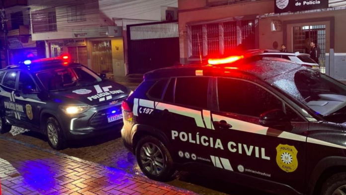 Duas viaturas da Polícia Civil estacionadas com as luzes do giroflex ligadas.