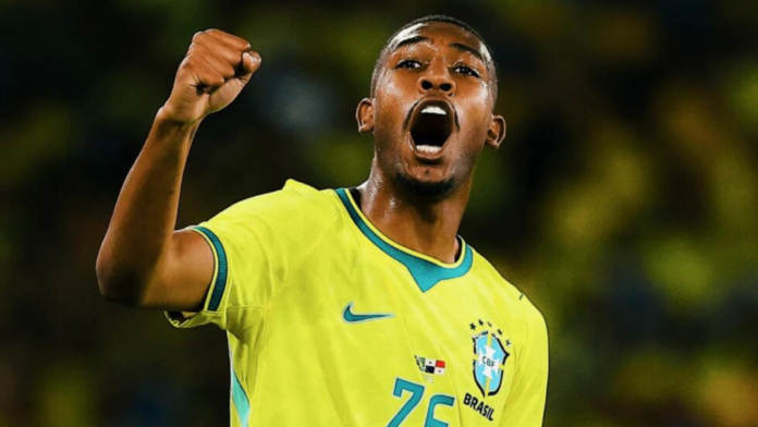 Jogador Rayan com camisa da Seleção Brasileira de Futebol com braço levantado comemorando