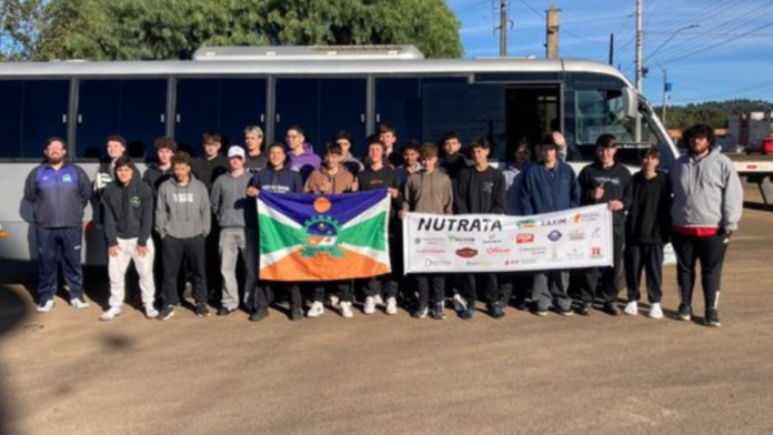 Equipes de basquete de Xaxim em frente ao ônibus que os levará para uma competição